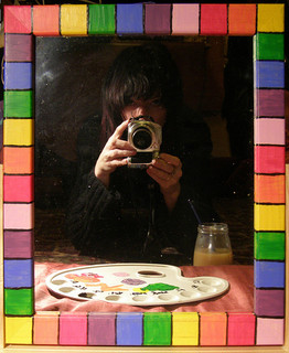 A man in a colored frame with a paint palette and a camera