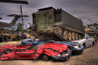 Cars getting compressed by a tank