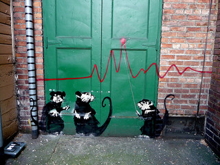 Banksy graffiti rats with a graph axis across a green door