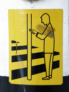 Sign showing a person pressing a button