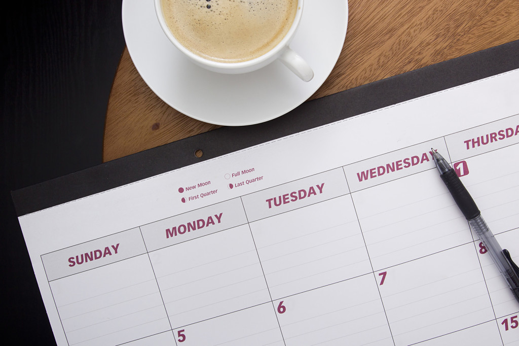 Office calendar planner on the coffee table with a cup of coffee.